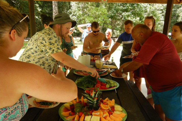 a group of people sitting at a table with a plate of food