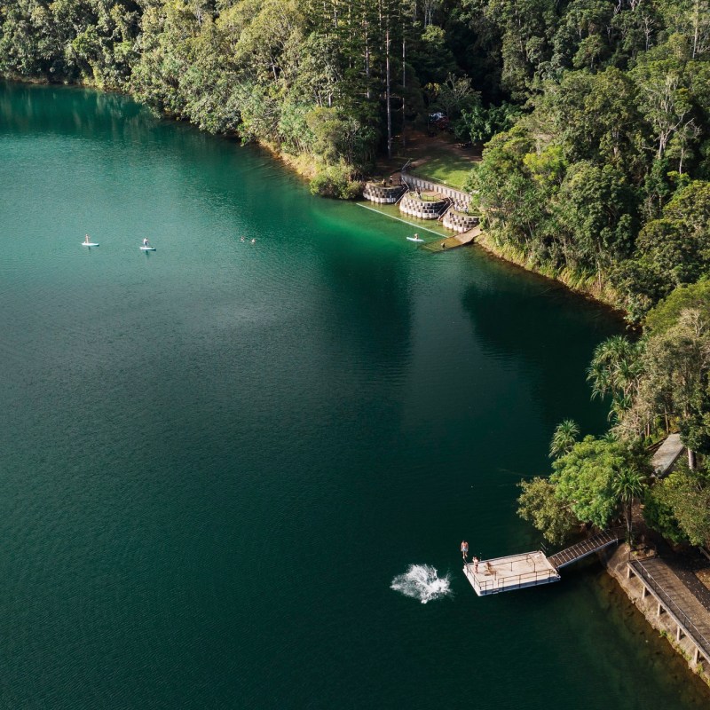 a boat floating along a river next to a body of water